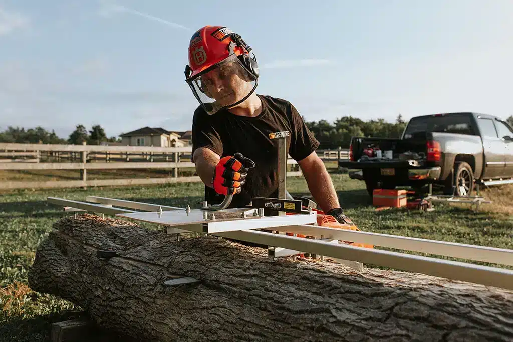 Carpenter uses sawmill on lumber